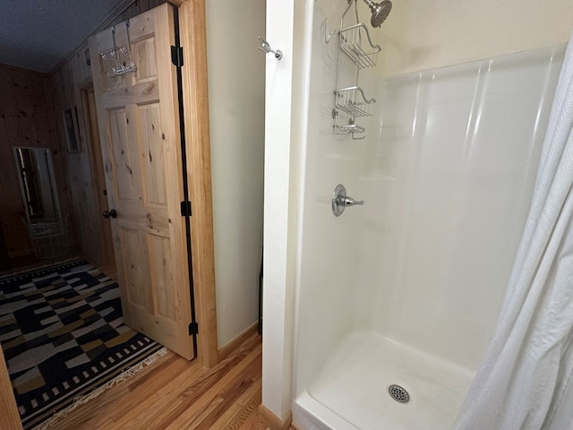 bathroom with a shower with shower curtain and hardwood / wood-style floors