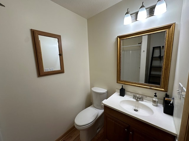 full bathroom featuring toilet, vanity, wood finished floors, and a shower