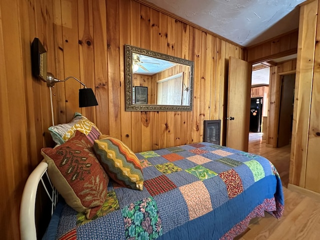 bedroom with wooden walls and wood-type flooring