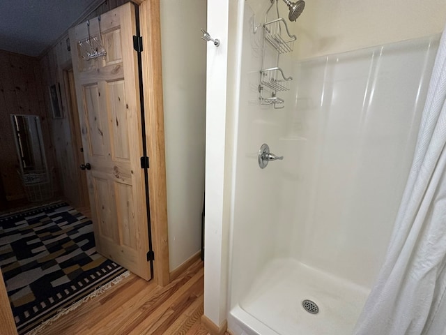 bathroom featuring wood finished floors and a stall shower