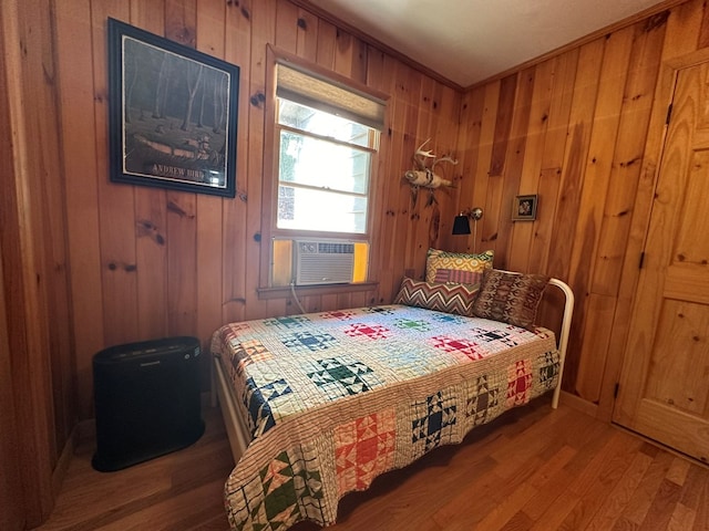 bedroom featuring wooden walls, wood finished floors, and cooling unit