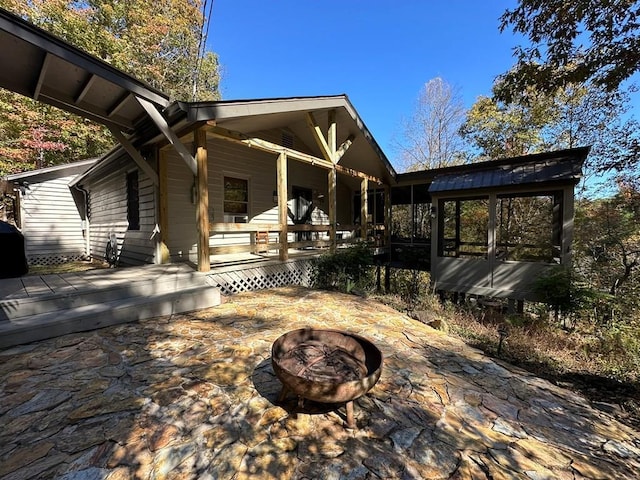 back of house featuring a fire pit, a patio, and covered porch