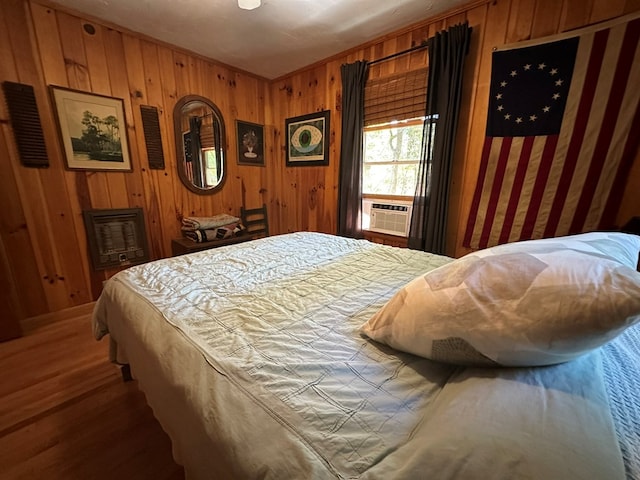 bedroom with wood walls, wood finished floors, and cooling unit