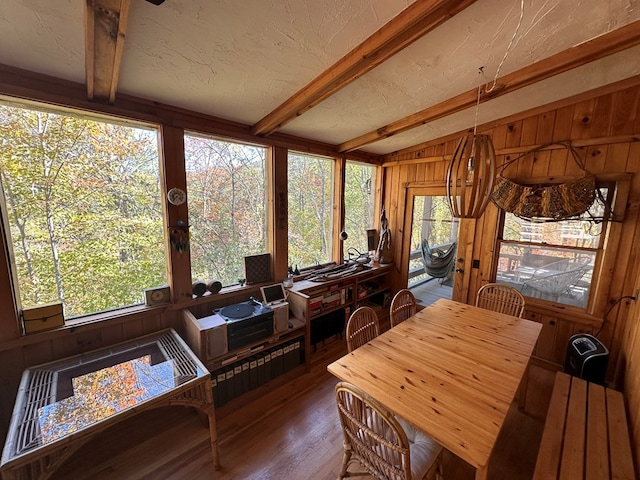 sunroom with vaulted ceiling with beams, wooden walls, and wood finished floors