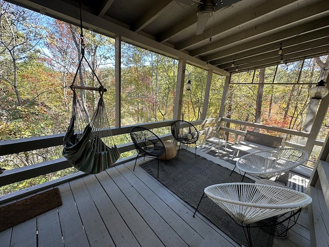 unfurnished sunroom featuring ceiling fan