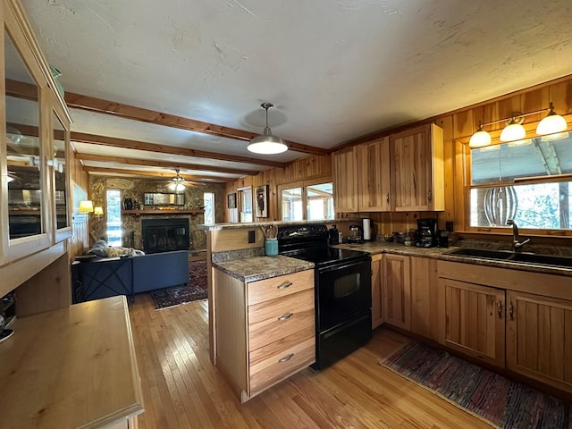 kitchen featuring black range with electric cooktop, a wealth of natural light, kitchen peninsula, and light hardwood / wood-style floors