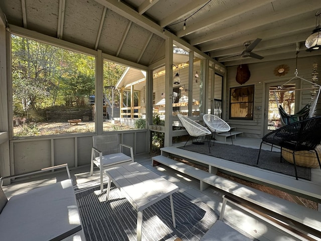 sunroom / solarium featuring ceiling fan, a healthy amount of sunlight, and vaulted ceiling