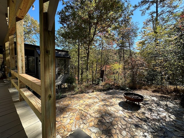 wooden deck featuring a patio area and a fire pit