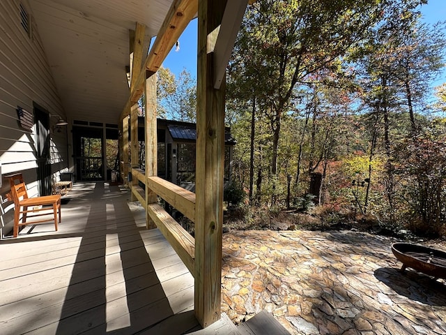 wooden deck with a fire pit and a patio area