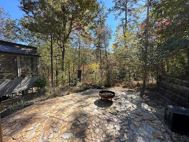 view of patio / terrace featuring a fire pit and a sunroom