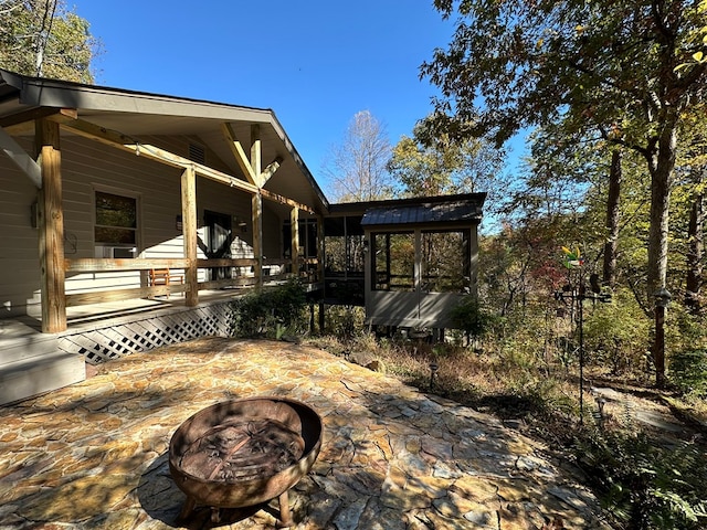 view of yard featuring a patio area, a porch, and an outdoor fire pit