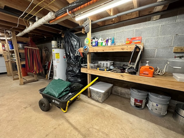 unfinished below grade area featuring water heater and washer / dryer