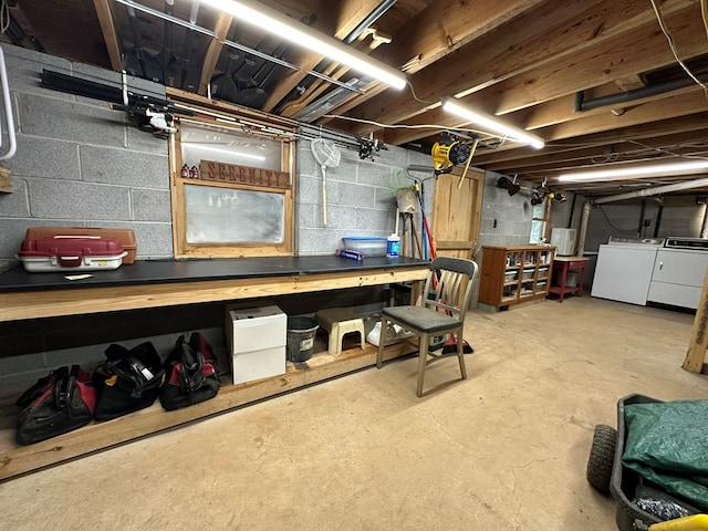unfinished below grade area with a workshop area, washing machine and clothes dryer, and concrete block wall