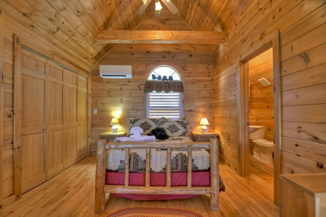 bedroom with wood walls, light hardwood / wood-style floors, and an AC wall unit