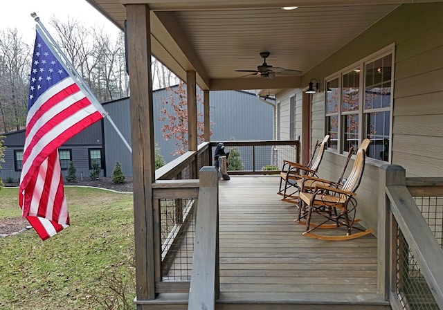 wooden deck with ceiling fan, a yard, and a porch