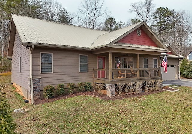 view of front of house featuring aphalt driveway, a porch, an attached garage, metal roof, and a front lawn