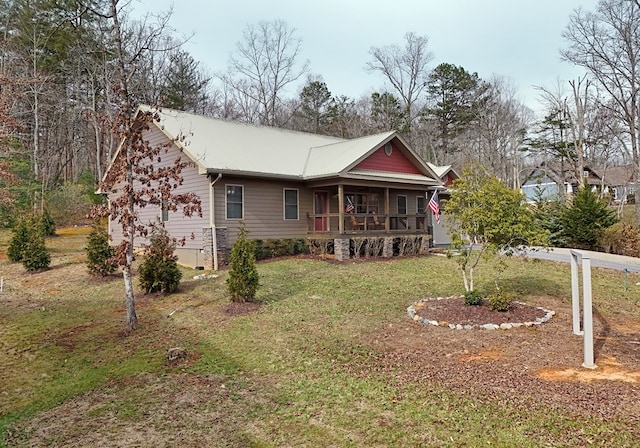 view of front of home featuring covered porch, metal roof, and a front yard