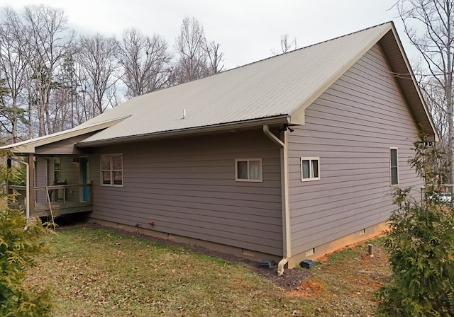 view of side of home with metal roof and crawl space