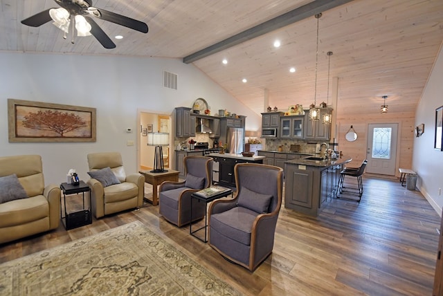 living room with wood ceiling, visible vents, wood finished floors, and beamed ceiling