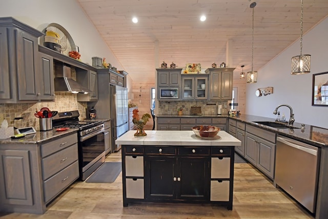 kitchen featuring wooden ceiling, stainless steel appliances, a peninsula, a sink, and vaulted ceiling