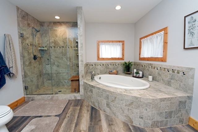 bathroom featuring recessed lighting, toilet, a shower stall, wood finished floors, and a bath