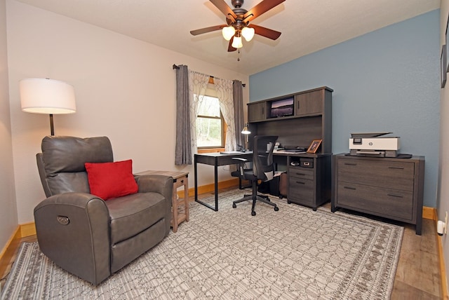 office area featuring a ceiling fan, light wood-type flooring, and baseboards