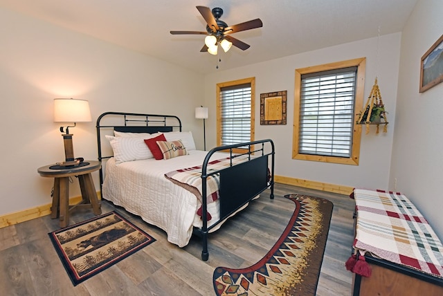 bedroom featuring ceiling fan, wood finished floors, and baseboards