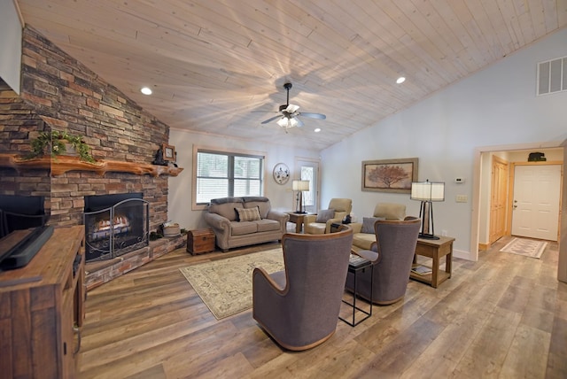 living room featuring recessed lighting, visible vents, a stone fireplace, wood finished floors, and wooden ceiling