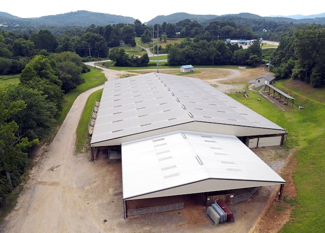 view of community with an outbuilding, a wooded view, and a mountain view