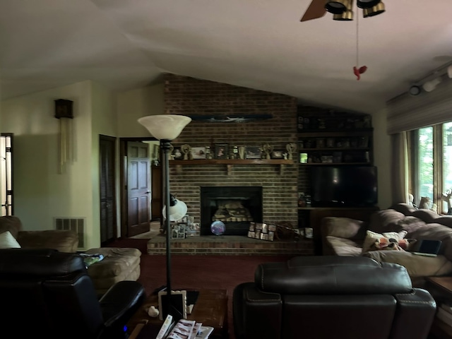 living room with a ceiling fan, visible vents, brick wall, lofted ceiling, and a brick fireplace