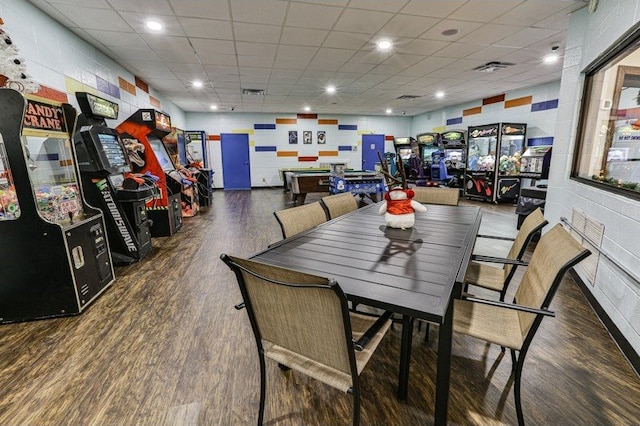 dining area with a paneled ceiling and dark hardwood / wood-style flooring