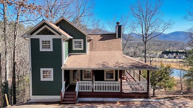 2103 Pooh Cor, Hiawassee, GA 30546 - view of front of house with covered porch, a chimney, a mountain view, and roof with shingles