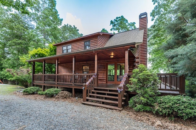 cabin with covered porch and a deck