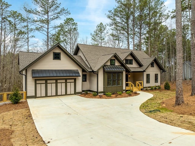 view of front of property with board and batten siding, a standing seam roof, a garage, concrete driveway, and a shingled roof