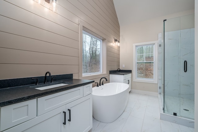 full bathroom featuring a wealth of natural light, a sink, marble finish floor, and a stall shower