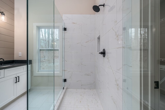 bathroom with vanity and a tile shower