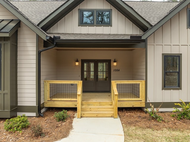 entrance to property with a shingled roof, board and batten siding, french doors, and covered porch