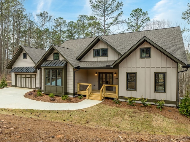 modern inspired farmhouse with roof with shingles, board and batten siding, a porch, french doors, and driveway