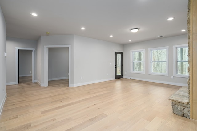 unfurnished living room with visible vents, baseboards, and light wood finished floors