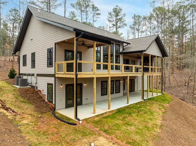 rear view of property featuring a ceiling fan, a patio area, central air condition unit, and a yard
