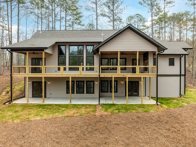 rear view of property with french doors, a ceiling fan, and a patio area