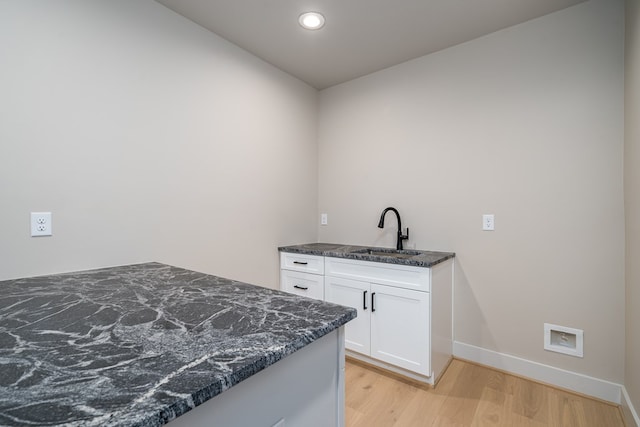 washroom with baseboards, a sink, light wood finished floors, and recessed lighting