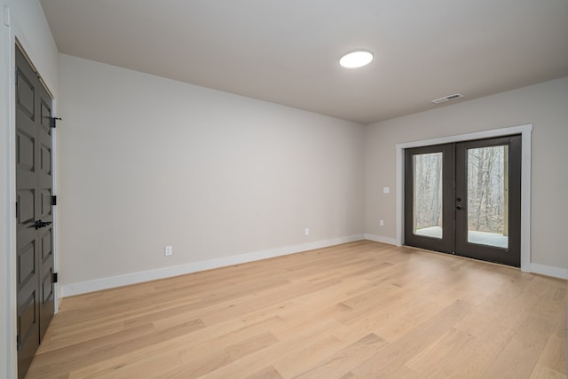 foyer with light wood-style floors, baseboards, french doors, and visible vents