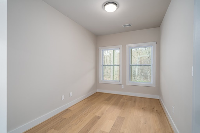 empty room with visible vents, baseboards, and light wood-type flooring