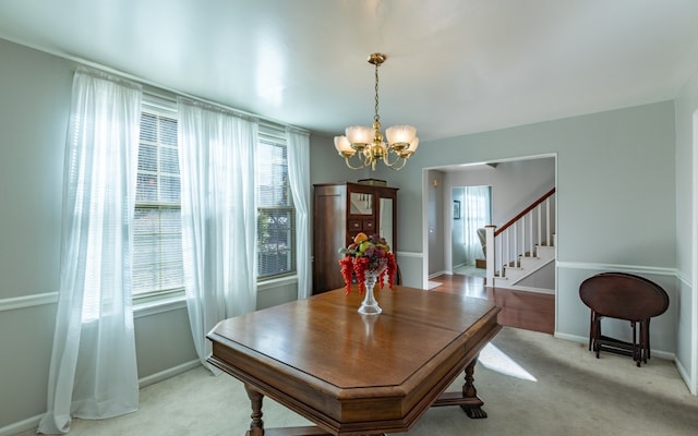 carpeted dining room with a chandelier and a healthy amount of sunlight