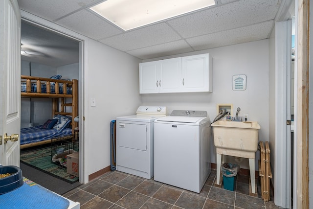 washroom with cabinets, sink, washer and clothes dryer, and dark tile patterned flooring