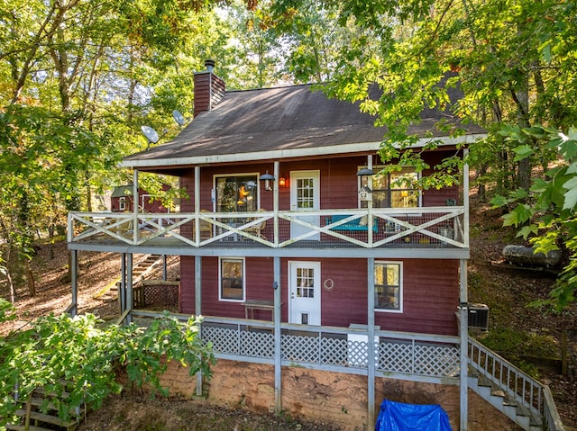 view of front of property featuring a balcony and central air condition unit