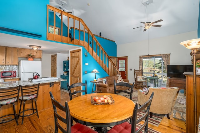 dining area with light hardwood / wood-style floors and ceiling fan