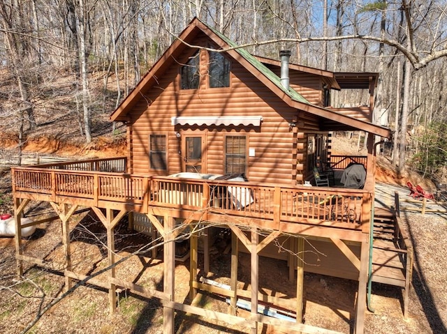 rear view of house featuring log siding and a wooden deck