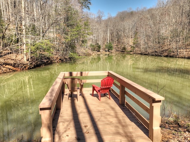 dock area with a water view and a wooded view